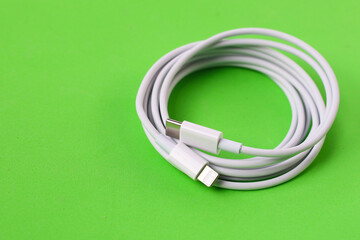 Cable with Type-C connector insulated, charging cable coiled on a green background.