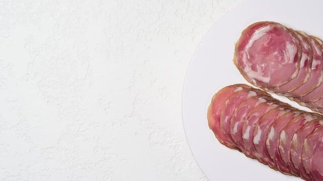 Thinly sliced prosciutto coppa capocollo presentation on white plate