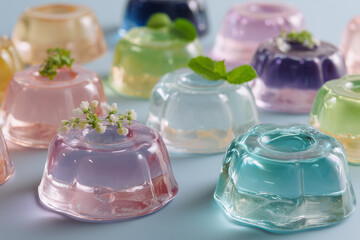 Pastel Gelatin Desserts with Floral Touch. Pastel gelatin desserts topped with mint and flowers, perfect for parties and celebrations.
