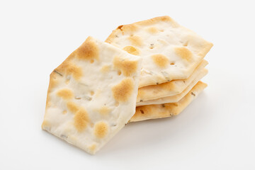 Whole grain crackers with spices and herbs isolated on white background. Dry salted cookies with crackers. Stack of various crispy wheat, rye and corn tortillas with sesame and sunflower seeds