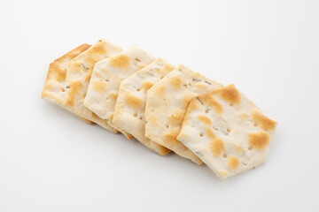 Whole grain crackers with spices and herbs isolated on white background. Dry salted cookies with crackers. Stack of various crispy wheat, rye and corn tortillas with sesame and sunflower seeds