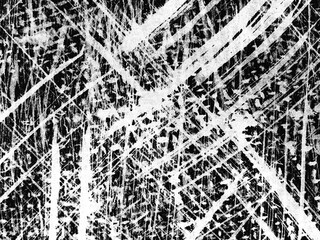 Intricate patterns of scratches on a textured black and white surface during daylight hours