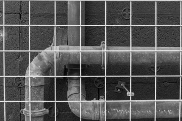 Industrial piping and grid structure in urban environment during daylight