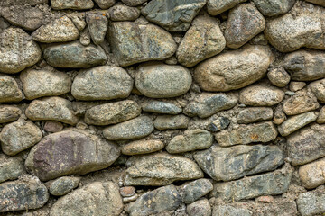 Rustic stone wall made with various sizes and shapes of round rocks