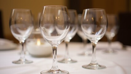 Elegant wine glasses poised on a crisp white tablecloth, bathed in soft light, setting the scene for a sophisticated dinner., ultra detailed, 8k resolution, HDR, professional