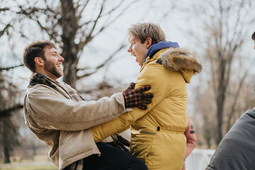 Young friends, dressed warmly, and laugh together in an outdoor setting. Their cheerful interaction...