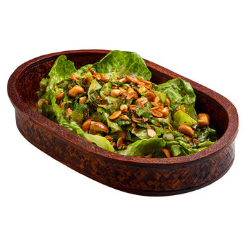 Burmese laphet thoke fermented tea leaf salad with peanuts and garlic chips in a lacquer tray, isolated on a white background