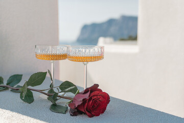 Rose Champagne Romance: Drinks and flower offer on a terrace near the sea, daylight romance moment.