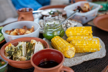 Corn Chicken Pesto: Feast displayed outdoors at daytime, for celebration or gathering.