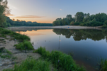 fishing rods on the bank of river