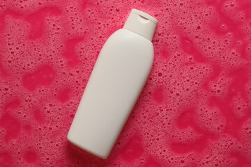 White Cosmetic Bottle on Vibrant Pink Foamy Background