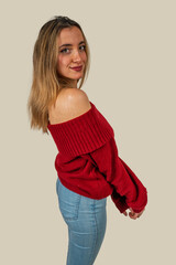 Young woman wearing red sweater and jeans posing in studio