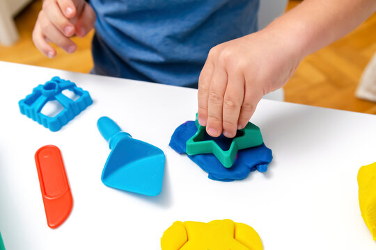 Child boy playing,molding plasticine.Kid sculpts with clay stucco.Play dough.art creativity,craft at kindergarten.Development of fine motor skills.sensory education at home