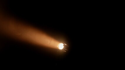 Bright spotlights beam from professional lighting equipment sparkle in the dark with floating smoke.