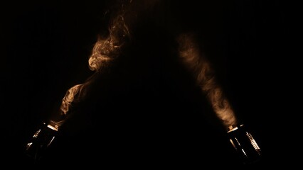Bright spotlights beam from professional lighting equipment sparkle in the dark with floating smoke.