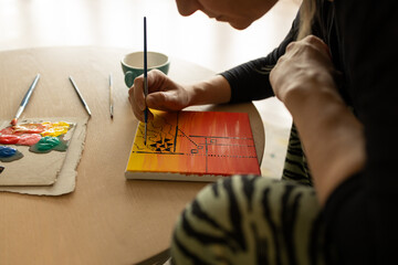 Woman artist painting abstract art on canvas at home