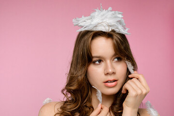 Woman with Feathers Against a Pink Background