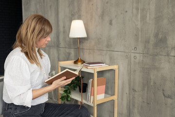 Woman reading a book in modern home office setting