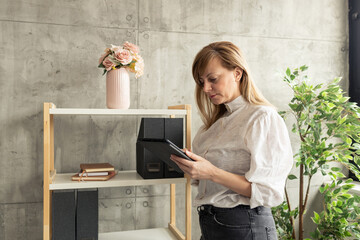 Businesswoman using digital tablet near bookshelf in modern office