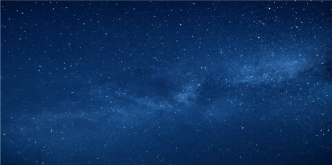 Starry blue night sky with a cosmic glow and distant galaxies