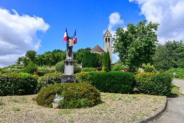 War memorial and church against a blue sky and white clouds. Photo location: Chermizy-Ailles (France)