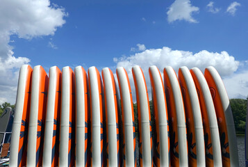 Front view on many vertical standing colorful sup boards on the pier against blue sky
