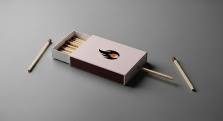 An open matchbox with wooden matches arranged on a gray surface