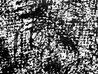 Abstract black and white texture created by paint splatters on a canvas surface during an art...