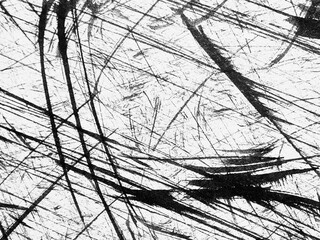 Abstract black and white textures created by scratches on a glossy surface during daylight hours