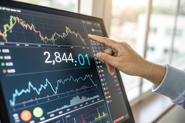 a close-up image of a hand pointing at a digital monitor