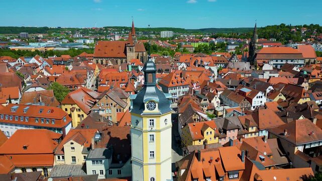 4K Aerial Drone Video of the Historic Herrieder Clock Tower and the St. Johannis Church in the Old Town area of Downtown Ansbach, Germany