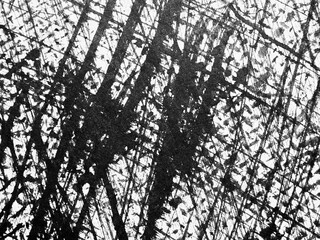 Abstract black and white texture created by overlapping lines and patterns on a textured surface in...