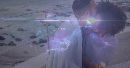 couple leaning holding mugs under blanket in travel ad cosmic particles sweeping inspiring laugh - Powered by Adobe