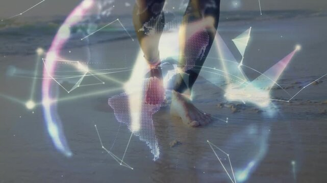 Man stepping into surf and creating 3D globe technology overlay while hoisting windsurf sail