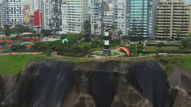 Lighthouse in Miraflores with paragliders soaring along the Costa Verde-Malec&oacute;n