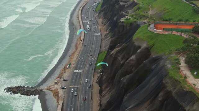 Paragliders soaring above the coastline along miraflores in lima, peru, aerial view