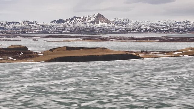Frozen Lake M&yacute;vatn with Sk&uacute;tusta&eth;ag&iacute;gar rootless cones and snow-covered peaks. Reykjahl&iacute;&eth;, Iceland