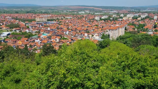 Revealing shot of the panoramic view of Leskovac&rsquo;s rooftops in southern Serbia, bathed in spring sunlight, reflecting everyday charm and the simplicity of local life under a clear blue sky
