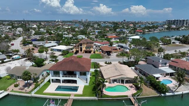 Luxury villas with swimming pool and river access in Treasure Island, Florida. Aerial flyover shot. Rich and wealthy neighborhood in ameican town.