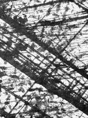 Black and white texture of scratched surface showing intersecting lines in an abstract design