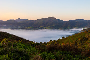 Fototapeta premium Mountains of the La Rhune Range Emerging from a Sea of Clouds at Sunrise in Sare