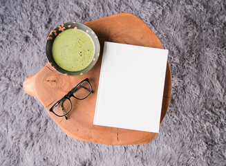 blank book cover mockup on coffee table with green matcha tea