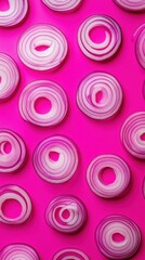  Flat lay of fresh red onion rings arranged in a repetitive pattern on a vibrant pink background. Ideal for modern food design and abstract kitchen compositions.