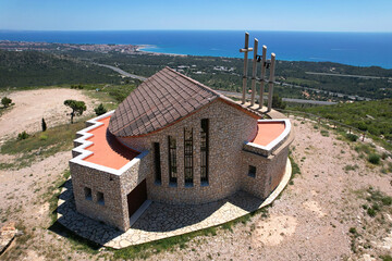 Drone view of Ermita de Sant Roc on sunny summer day. L'Hospitalet de l'Infant, Tarragona, Spain.