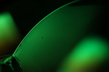 Green liquid surface, green on black, scientific background 