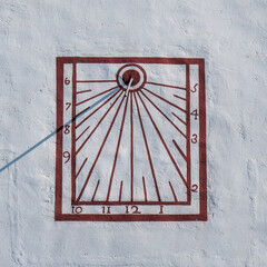 Sundial on the wall of Hermitage of Mare de Déu de la Roca de Mont-roig on sunny summer day. Mont-roig, Tarragona, Spain.
