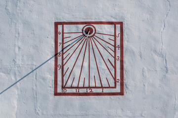 Sundial on the wall of Hermitage of Mare de Déu de la Roca on sunny day. Mont-roig, Tarragona, Spain.