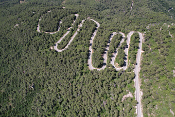 Aerial view of hairpin turns road between Vilaplana and Mussara on sunny summer day. Tarragona, Spain.