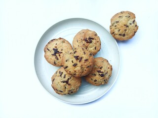 sweet and crunchy chocolate cookies or dry chocolate cake on white plate with white background.
