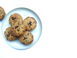 sweet and crunchy chocolate cookies or dry chocolate cake on white plate with white background.